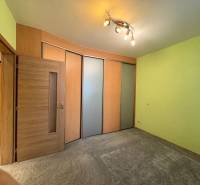 NOVINKA .... Na  predaj 3 izbový byt na sídlisku SNP v Michalovciach - Izba v 3-izbovom byte s posuvnými dverami, zelenými stenami a bodovým osvetlením.