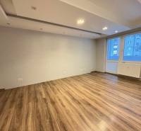 NOVINKA .... Na  predaj 3 izbový byt na sídlisku SNP v Michalovciach - Obývacia izba v 3-izbovom byte s podlahou s dreveným dekorom a veľkým oknom.