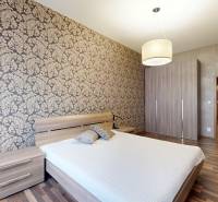 RIVERS | FIVE STAR RESIDENCE _ 3i byt na prenájom - Spálňa v 3-izbovom byte so vzorovanou tapetou a podlahou s dreveným dekorom.