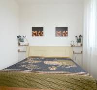 ANTOLSKÁ, 2-i byt, 54 m2 – novostavba REZIDENCIA DRAŽDIAK, zariadený - Spálňa v 2-izbovom byte so svetlou posteľou a dekoračnými obrázkami na stene.