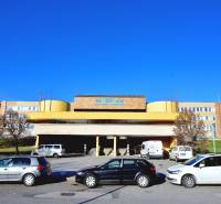 ANTOLSKÁ, 2-i byt, 54 m2 – novostavba REZIDENCIA DRAŽDIAK, zariadený - Budova nemocnice na Antolskej ulici v Petržalke, Bratislava, s parkoviskom a autami.