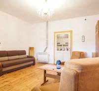 Rodinný dom s garážou na ul. Pod kopcom, Nové Zámky, 649m2 - Obývačka v rodinnom dome s podlahou s dreveným dekorom, sedačkou a kreslami.