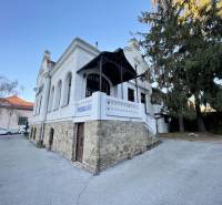 PREŠOV-ŠIRŠIE CENTRUM,POLYFUNKČNÁ BUDOVA,VL.PARKOVISKO,UL.VAJANSKÉHO - Budova na Vajanského ulici v Prešove s elegantným kamenným základom a bielou fasádou.