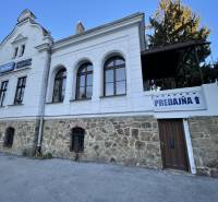 PREŠOV-ŠIRŠIE CENTRUM,POLYFUNKČNÁ BUDOVA,VL.PARKOVISKO,UL.VAJANSKÉHO - Budova na Vajanského ulici v Prešove s kamenným prízemím a nápisom 