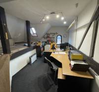 PREŠOV-ŠIRŠIE CENTRUM,POLYFUNKČNÁ BUDOVA,VL.PARKOVISKO,UL.VAJANSKÉHO - Kancelária v budove s drevenými trámami, vybavená stolmi a kancelárskymi potrebami.