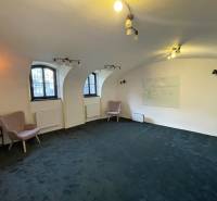 PREŠOV-ŠIRŠIE CENTRUM,POLYFUNKČNÁ BUDOVA,VL.PARKOVISKO,UL.VAJANSKÉHO - Interiér budovy s oblúkovými oknami, zeleným kobercom a nástennou tabuľou.