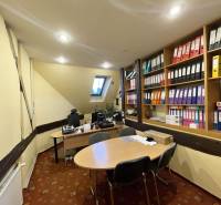 PREŠOV-ŠIRŠIE CENTRUM,POLYFUNKČNÁ BUDOVA,VL.PARKOVISKO,UL.VAJANSKÉHO - Kancelária v budove so šikmým stropom, pracovnými stolmi a policami s dokumentmi.