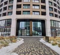 Prenájom 2-izb. byt, SKY PARK, 4. veža, Staré Mesto - Budova na Bottovej ulici v Bratislave – Staré Mesto s obchodnými priestormi a chodníkom so snehom.