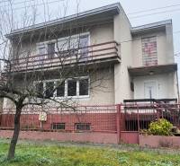 PRIESTRANNÝ 7-IZBOVÝ RODINNÝ DOM S VEĽKÝM POZEMKOM V DLHEJ NAD VÁHOM - Rodinný dom v Dlhej nad Váhom s betónovou fasádou, balkónom a predzáhradkou.