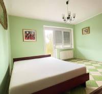 PRIESTRANNÝ 7-IZBOVÝ RODINNÝ DOM S VEĽKÝM POZEMKOM V DLHEJ NAD VÁHOM  - Spálňa v rodinnom dome s posteľou, pastelovými stenami a šachovnicovou podlahou.