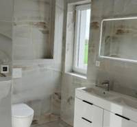 REZERVOVANÉ Na predaj 3-izbový byt v štandarde - Novostavba Diakovce - Kúpeľňa s moderným umývadlom, zrkadlom s osvetlením a obkladmi v 3-izbovom byte.