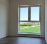 REZERVOVANÉ Na predaj 3-izbový byt v štandarde - Novostavba Diakovce - Svetlá miestnosť v 3-izbovom byte s podlahou s dreveným dekorom a veľkým oknom.