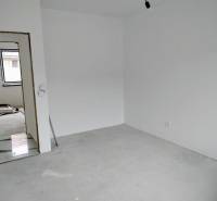 Novostavba 4-izbového rodinného dvojdomu v obci Žihárec - Prázdna miestnosť s bielymi stenami v rodinnom dome, vidno dvere a okno.