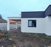 Novostavba 4-izbového rodinného dvojdomu v obci Žihárec - Rodinný dom v Žihárci s modernou fasádou a priľahlou pergolou na dvore.