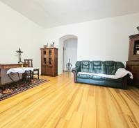  Veľkometrážny 3 izbový byt v kúpeľnom meste Trenčianske Teplice  - Obývacia izba v 3-izbovom byte s podlahou s dreveným dekorom, pohovkou a dreveným nábytkom.