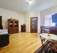  Veľkometrážny 3 izbový byt v kúpeľnom meste Trenčianske Teplice  - Obývačka v 3-izbovom byte s podlahou s dreveným dekorom a nábytkom z tmavého dreva.