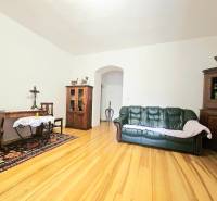  Veľkometrážny 3 izbový byt v kúpeľnom meste Trenčianske Teplice  - Obývacia izba v 3-izbovom byte s podlahou s dreveným dekorom a dreveným nábytkom.