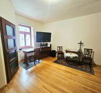  Veľkometrážny 3 izbový byt v kúpeľnom meste Trenčianske Teplice  - Izba v 3-izbovom byte s podlahou s dreveným dekorom a televízorom na stolíku.