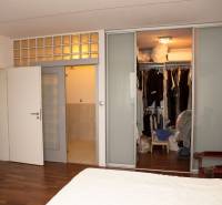 Na predaj rodinný dom na Súľovskej 56 v Bratislave - Spálňa v rodinnom dome s posuvnými dverami a šatníkom, podlaha s dreveným dekorom.