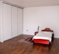 Na predaj rodinný dom na Súľovskej 56 v Bratislave - Detská izba v rodinnom dome s posteľou v tvare auta a podlahou s dreveným dekorom.