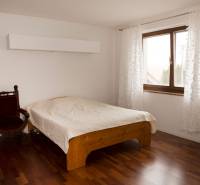 Na predaj rodinný dom na Súľovskej 56 v Bratislave - Spálňa v rodinnom dome s posteľou, kreslom a podlahou s dreveným dekorom.