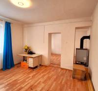 Rodinný dom po čiastočnej rekonštrukcii - Rodinný dom s podlahou s dreveným dekorom, okno so záclonami a písací stôl.