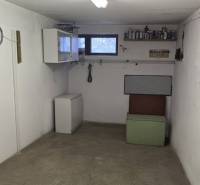 3-izbový byt so záhradou a garážou – Sadová ulica, Piešťany - Malá miestnosť so starým nábytkom, oknom, poličkou a hodinami na stene.