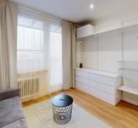  PRENÁJOM - Garsónka s balkónom Holíč, Lúčky 11 - Garsónka s pohovkou, úložným priestorom, podlahou s dreveným dekorom a bielymi závesmi.