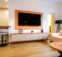 PREDAJ | 3i tehlový BYT, 90 m², centrum PO, balkón , Klimatizácia ... - Obývačka v 3-izbovom byte s podlahou s dreveným dekorom, televízorom a krémovým sedačkami.