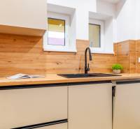 PREDAJ | 3i tehlový BYT, 90 m², centrum PO, balkón , Klimatizácia ... - Kuchyňa v 3-izbovom byte s dreveným dekorom, umývadlom a skrinkami.