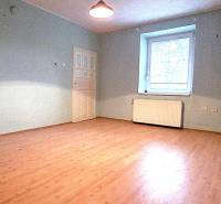 Na predaj rodinný dom Levice!. - Izba v rodinnom dome s podlahou s dreveným dekorom a modrými stenami.