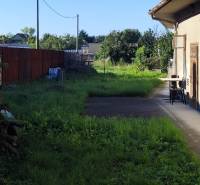 Slnečný pozemok v centre obce Réca, 756 m² - Dvor v Reci vhodný na bývanie, pozemky sú ohraničené plotom a zelenými kríkmi.