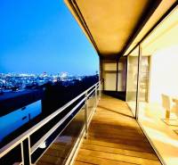 Koliba:Na prenájom 4i, lux. byt,terasa, bazén/eng.text inside - Nočný výhľad z balkóna 4-izbového bytu s podlahou s dreveným dekorom.