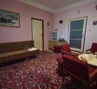 4i rodinný dom s garážou, 8á pozemok s vlastnou studňou, Križovany - Obývacia izba v rodinnom dome s červeným kobercom a dreveným nábytkom.