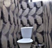 Kaviareň v Top lokalite mesta Šaľa na predaj - Toaleta s dekoratívnou tapetou s listovým vzorom a malým oknom vyššie.