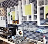 Kaviareň v Top lokalite mesta Šaľa na predaj - Interiér obchodných priestorov s kávovarom, regálmi, pohármi a nápojmi na poličkách.