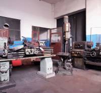 Prevádzková budova-AUTOSERVIS na predaj vo Veľkých Úľanoch - Výrobné priestory so starými strojmi a neomietnutými stenami, podlaha s dreveným dekorom.