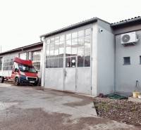 Prevádzková budova-AUTOSERVIS na predaj vo Veľkých Úľanoch - Výrobné priestory vo Veľkých Úľanoch s plechovými bránami a červeným autom.