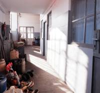 Prevádzková budova-AUTOSERVIS na predaj vo Veľkých Úľanoch - Úzky chodba vo výrobných priestoroch s uskladnenými nádobami a náradím.