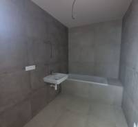 POSLEDNÁ Novostavba 4-izb rodinného domu v lukratívnej časti mesta - Kúpeľňa s veľkoformátovými šedými dlaždicami, umývadlom a vaňou v Rodinnom dome.