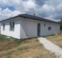 POSLEDNÁ Novostavba 4-izb rodinného domu v lukratívnej časti mesta - Rodinný dom v Galante s bielym exteriérom na trávnatom pozemku pod oblačnou oblohou.