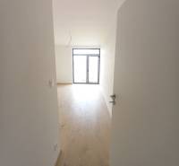 POSLEDNÁ Novostavba 4-izb rodinného domu v lukratívnej časti mesta - Interiér rodinného domu s podlahou s dreveným dekorom a veľkým oknom.