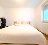 Miesto, kde sa budete cítiť doma–2-izbový byt na sídlisku West-Galana - Spálňa v 2-izbovom byte s posteľou, otvoreným šatníkom a podlahou s dreveným dekorom.