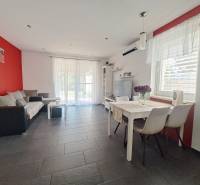 Predvianočná zľava! Na predaj krásny 4izb dom v obci Čierny Brod  - Obývačka v rodinnom dome s červenou stenou, sivou dlažbou a bielym nábytkom.