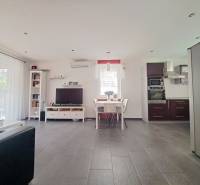 Predvianočná zľava! Na predaj krásny 4izb dom v obci Čierny Brod  - Obývacia izba s TV, kuchyňou a jedálenským stolom, podlaha s dreveným dekorom.