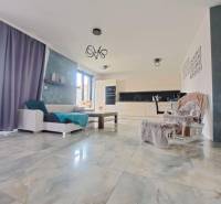 Neodolateľná ponuka! 4-izbová novostavba Galanta-Kolónia za super cenu - Obývacia izba s veľkými oknami a svetlými dlaždicami v rodinnom dome.