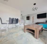 Neodolateľná ponuka! 4-izbová novostavba Galanta-Kolónia za super cenu - Interiér rodinného domu so svetlými dlaždicami, moderným nábytkom a stenou s televízorom.