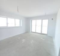 SKOLAUDOVANÉ! Novostavba 2,3 izbových bytov a nebytových priestorov - Priestranná izba v 2-izbovom byte so svetlými stenami a veľkými oknami.