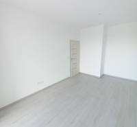 SKOLAUDOVANÉ! Novostavba 2-3 izbových bytov s pozemkom Richtárske pole - Miestnosť v 2-izbovom byte s bielymi stenami a podlahou s dreveným dekorom.