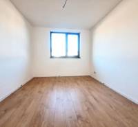 REZERVOVANÉ! Posledná novostavba 4-izbového dvojdomu v štandarde - Výhľad na izbu s bielymi stenami a podlahou s dreveným dekorom v rodinnom dome.